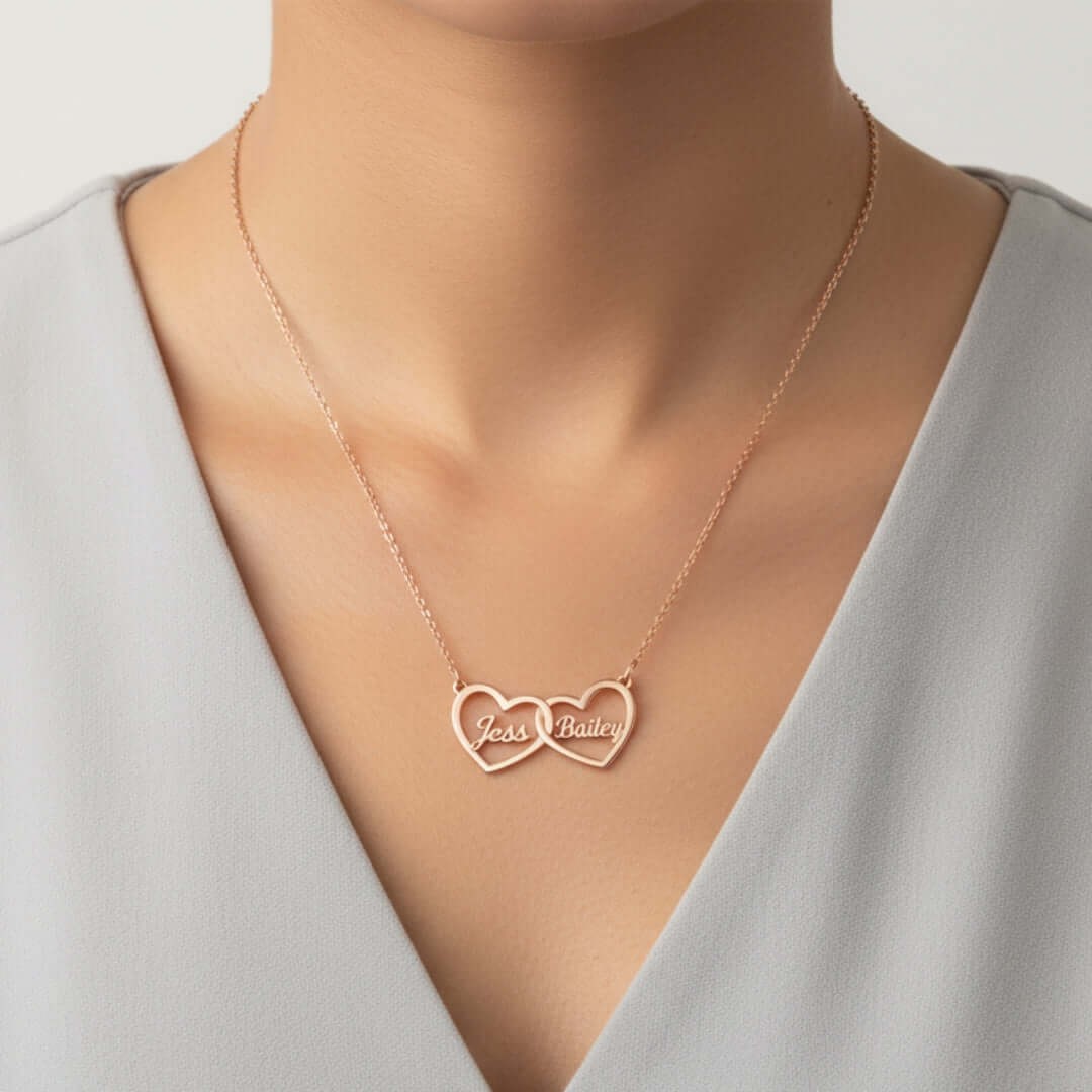 Two Hearts Necklace in rose gold with engraving, personalized with names Jess and Bailey, symbolizing love and bond.