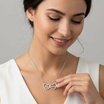 Woman wearing a Two Hearts Necklace in silver, showcasing personalized engraving and a bond of love.
